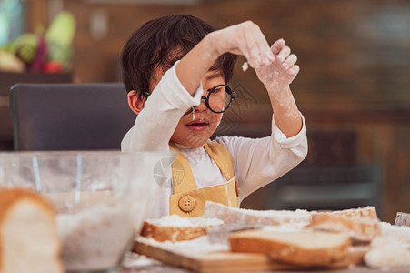 喜欢烘烤面包的亚洲小快乐男孩在家厨房里很滑稽人们的生活方式和家庭自制食物原料概念烤圣诞蛋糕和饼干人们的生活方式和家庭自制食品成厨图片