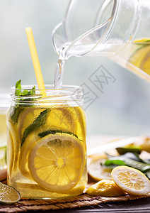 柠檬水从罐子倒进中强化和刷新冷饮天然产物概念从罐子倒进中的柠檬水黄色野餐液体图片