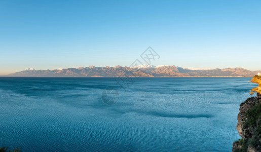 在阳光明媚的冬季日有海和雪山的安塔利亚全景风海岸热带天空图片