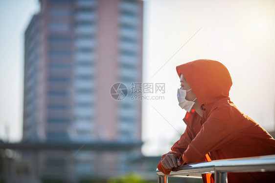 身体空气亚裔年轻健身运动女在赛跑她戴着面具保护城市灰尘与污染在城市中使用防尘和污工具日落图片