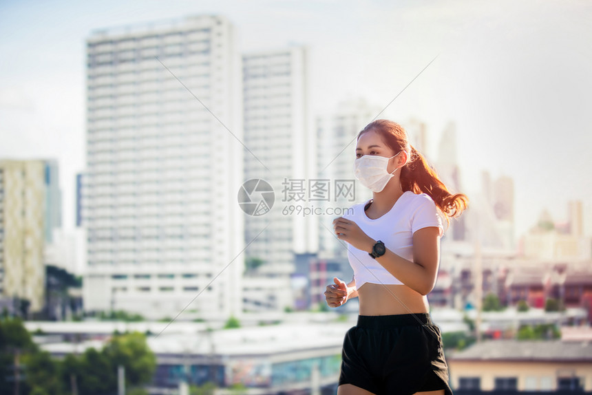 有毒的马拉松亚裔年轻健身运动女在赛跑她戴着面具保护城市灰尘与污染在城市中使用防尘和污工具穿图片