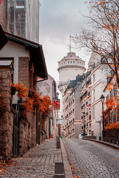 阳光明媚的秋天午后蒙马特街道金色的树木和鹅卵石小巷法国巴黎的秋天老城区阳光明媚的秋天下午蒙马特街道老城市心历史图片