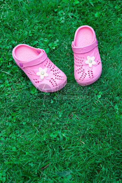 莫斯科屋三叶草粉红孩子在绿复制空间顶端视野上的拖鞋位于与自然团结的垂直概念框架之上用于儿童储存产品母亲博客育儿杂志图片