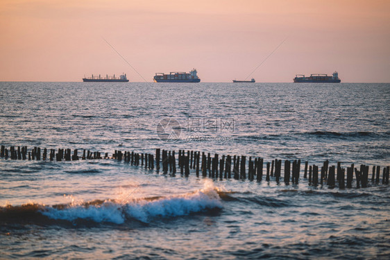 国际集装箱货船在黄昏的海面上物流和运输货航等国际集装箱货船的物流和运输海岸天空黎明图片