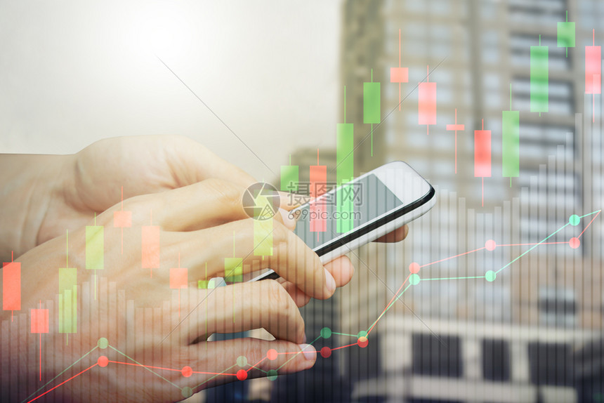 手用智能机在屏幕上进行网智能电话交易使用Candlestick图表显示股票市场和城背景成功经纪人笔记本图片