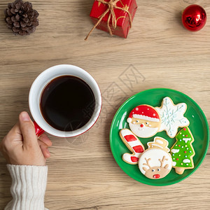 展示礼物圣诞快乐女人手握着咖啡杯和自制饼干在餐桌Xmas晚宴派对节假日和新年快乐的概念茶图片