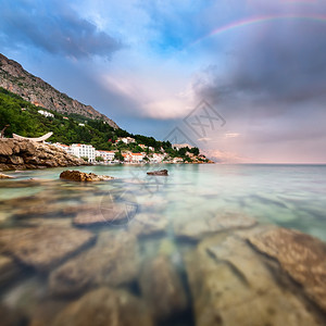 建筑学克罗地亚达尔马提Dalmatia雨后洛基海滩和小村庄上的彩虹船夏天图片