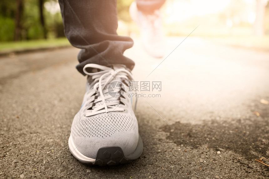 腿女晚上日落时穿运动鞋在中央公园跑步的女运动员穿着鞋阳光图片