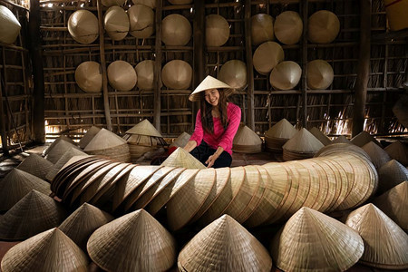 行业东方的制造商在越南霍希明市ApThoiPhuoc村古老传统房屋中亚洲旅行女手工艺匠在传统术家概念中制作传统维特南帽图片