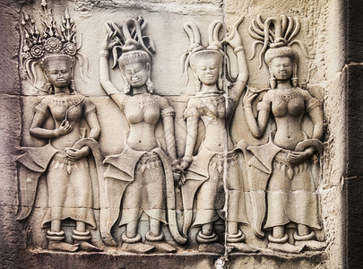 内地点柬埔寨吴哥瓦墙上古老的石雕刻画有四名妇女站在一起她们穿着类似的衣服但戴高雅的帽子精神图片