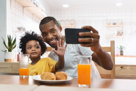 非洲父子在用智能手机与家人进行视频聊天图片