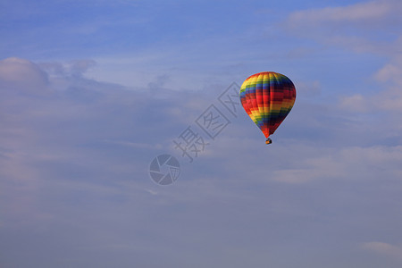 运动蓝色天空中美丽多和摩特利气球的飞逝在蓝色天空中闪耀着美丽的多色和摩特利气球的光线下将旅游者们的篮子升至蓝天骑热气球图片