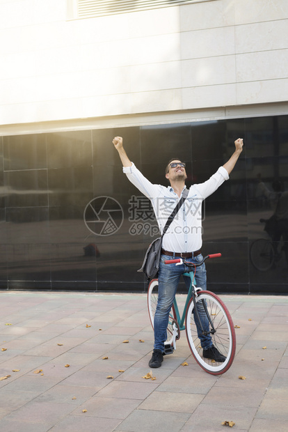 企业家男微笑商人在办公室建筑背景中举起双臂张开手掌用脸朝上看打开手掌快乐成功和就的概念图片