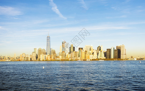 高的纽约天际线在明亮的一天观看自由岛城市水图片