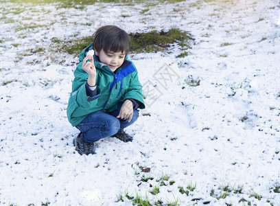 白色的长得有趣喜乐快的男孩扔起雪选择关注的孩子在冬季初户外玩雪愉快球图片