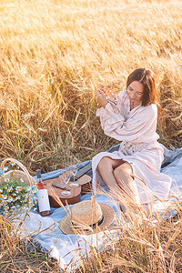 小麦田中美丽的浪漫女人在小麦田中野餐在小麦田中美女孩手握成熟的麦子农业明亮年轻图片