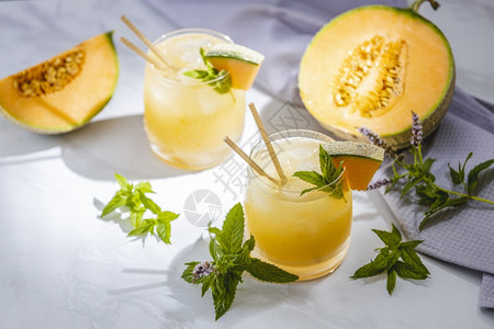 薄荷瓜汁柠檬杯子里有冰和瓜片的柠檬水夹满了叶鸡尾酒自制图片