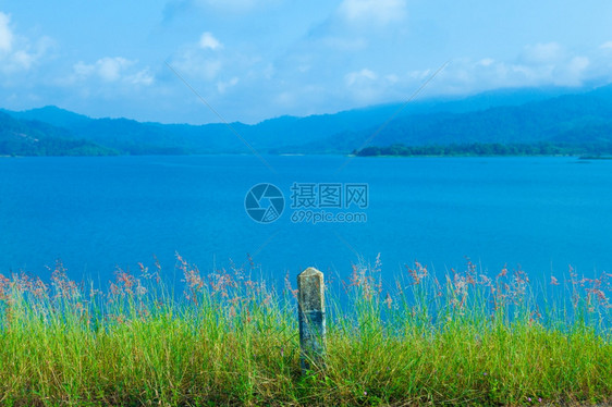 天气蓝色的田园诗般湖和山后面路边的草地在湖和山后面图片