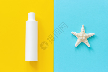 颜色布局黄和蓝纸背景上的海星和白色瓶防晒霜模拟板用于刻字文本或您的设计顶视图白色的图片