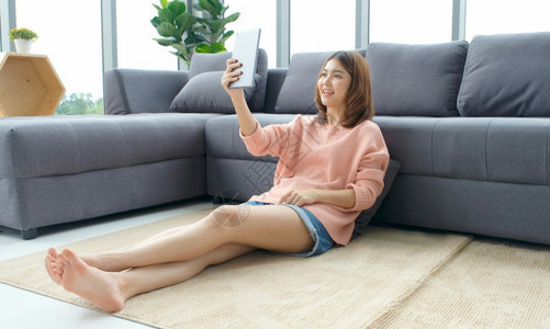 视频电话会议在数字平板电脑上进行视频聊天的快乐女孩在家手机上进行视频聊天的亚洲妇女在智能手机上谈论视频电话的亚裔妇女与家人打招呼图片