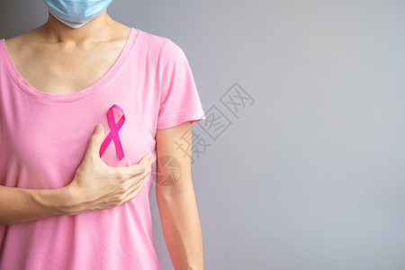 女治愈胸部10月提高乳腺癌意识月穿粉红T恤的老年妇女手握粉丝带支持人们生活和疾病国际妇女母亲和世界癌症日概念一10月乳癌意识穿着图片