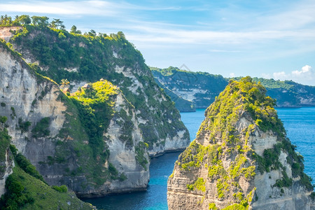 印度尼西亚岩石岛海岸在礁上雨林洛基大洋海岸和棚屋的悬崖顶边几座小屋支撑树假期图片