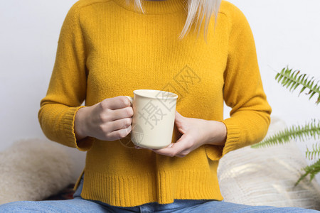 淑女饮料脸快乐的年轻女士拿着一杯茶或咖啡带着一束温暖的笑容看着摄影机图片