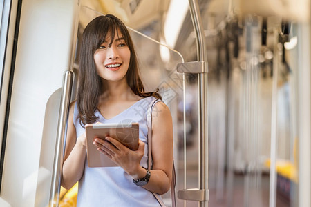 东南平台亚洲青年女乘客在大城市japanesechinese朝韩生活方式和日常通勤和运输概念上旅行时利用地铁火车技术平板进行社会图片
