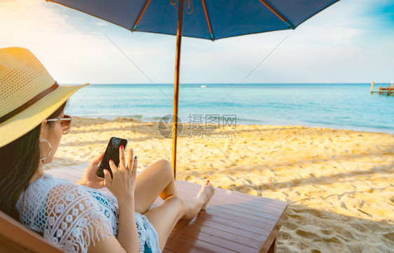 在沙滩椅上享受海边的人图片