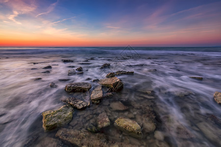 欧洲旅游美丽的岩石海滩中块模糊日出时黑海天空多彩保加利亚风景与海浪和岩石相伴暮图片