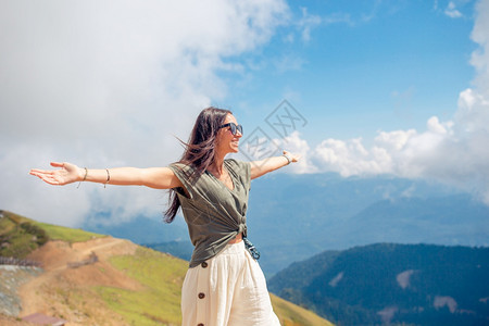 美丽快乐的年轻女子在山上度假美丽的风景快乐的年轻女子在山中雾的背景漂流胡托尔幸福图片