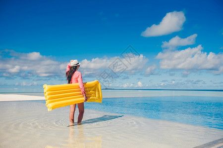 棕褐色年轻女士在无限游泳池里有空气床垫在游泳池里放松的年轻快乐女人假期喜悦图片
