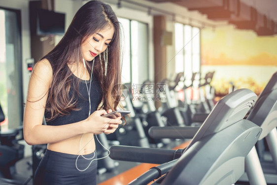 商业触碰亚洲女在健身房运动锻炼或体力训练时使用智能电话有关运动放松和技术概念运动和健康护理主题快乐与舒适的心情成人图片