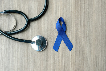 Colon癌症意识含听诊器的深蓝丝带以支持人们生活和疾病保健以及世界癌症日概念Colon癌症意识女士健康结肠炎图片