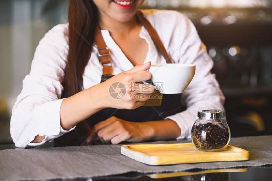 女士在室内关闭白咖啡杯为客户提供有美丽的亚洲女律师协会背景的白咖啡杯供职和业服务食品和饮料咖啡店及和餐馆拥有权单位美元所有权图片