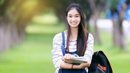 拿着书的年轻微笑女孩图片