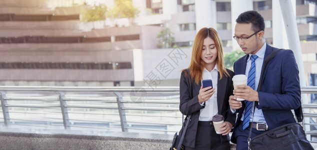 团队合作保持商业女人在镇上喝咖啡使用智能手机在办公室城外的全景手握着咖啡杯智能电话和商务伙伴乐盘聊天PanoramaHands工图片