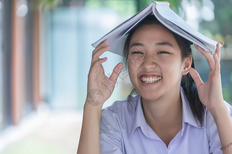 穿着制服的漂亮女孩亚洲青年大学生在咖啡店阅读情绪轻松的书籍以便在线学习临时商务社交会议或教育概念在咖啡店学习书以放松情绪学习网上图片