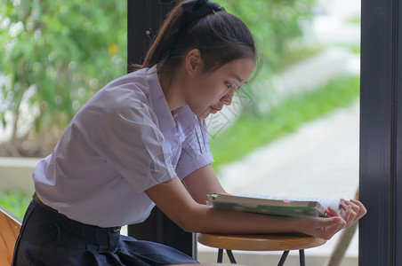 笔记本电脑图书馆学生们穿着制服的漂亮女孩亚洲青年大学生在咖啡店阅读情绪轻松的书籍以便在线学习临时商务社交会议或教育概念在咖啡店学图片