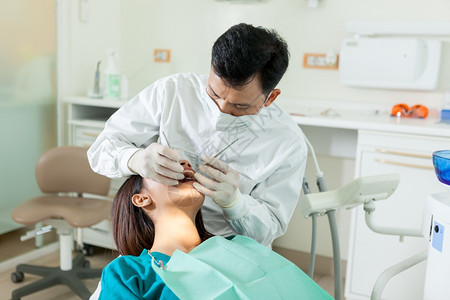 一名年轻的女性在牙医办公室接受口腔检查图片