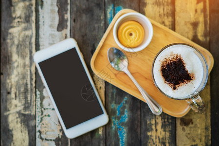 手机黑暗的早上餐或咖啡时间在店工作自由职业者中工作每天上午或咖啡时间工作和休息与木质布料背景早餐或咖啡时间在店工作马克杯图片