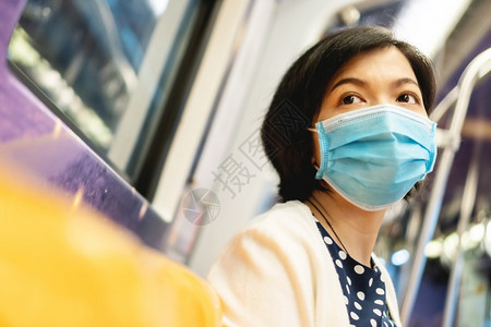 乘客身戴保护面罩的亚洲美丽女以保护冠状共食19或通勤列车地铁内的空气污染与新正常人一起前往地下工作的女青年地铁孩人们图片