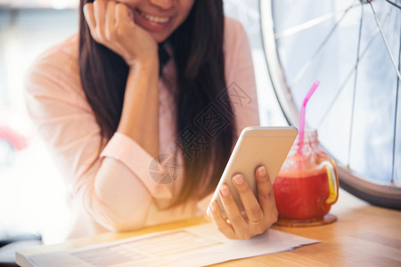 屏幕安全的亚裔女使用Pipad购物网站的智能手机路微笑着面容的脸幸福与藉手持机检查网上购物站邮件的亚裔女阅读文章Blogvlog图片