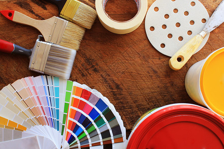为了用于木质背景上家庭装修的各种绘画工具配件和颜色样品用于木质背景上家庭装修的各种绘画工具配件和颜色样品手套桶图片