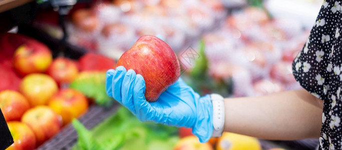 拐点食物购中心妇女在超市或杂货店内戴硝化手套和持有红苹果子保护阴冠渗透卫生新正常和19大流行后的生活图片