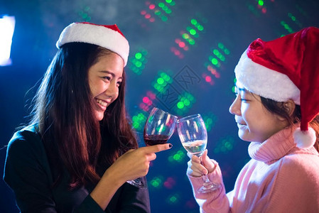 两位亚洲女庆祝圣诞节与新年派对在酒吧人与夜生活概念党与动主题ClinkGlass一同庆祝圣诞与新年晚宴爱惊喜享受图片