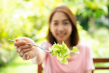 素食主义者人们蔬菜坐在花园旁边房子阳台上吃健康绿色沙拉的保健和营养食品概念她认为在家庭园圃旁边的露台里生活着一个健康的绿色沙拉图片