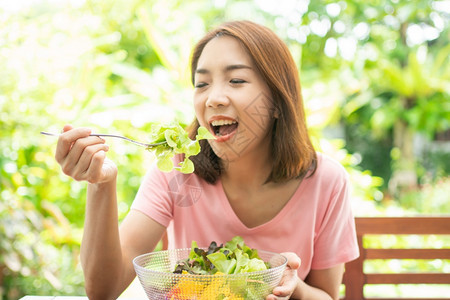 食物坐在花园旁边房子阳台上吃健康绿色沙拉的保健和营养食品概念她认为在家庭园圃旁边的露台里生活着一个健康的绿色沙拉女士有机的图片