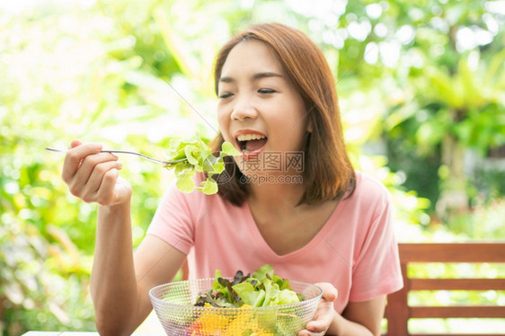 食物坐在花园旁边房子阳台上吃健康绿色沙拉的保健和营养食品概念她认为在家庭园圃旁边的露台里生活着一个健康的绿色沙拉女士有机的图片