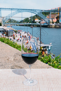 葡萄牙波尔图杜罗河上俯瞰CaisdaRibeira和PontedeDomLuisI的红酒杯选择焦点红酒杯旅游路易斯廷托图片